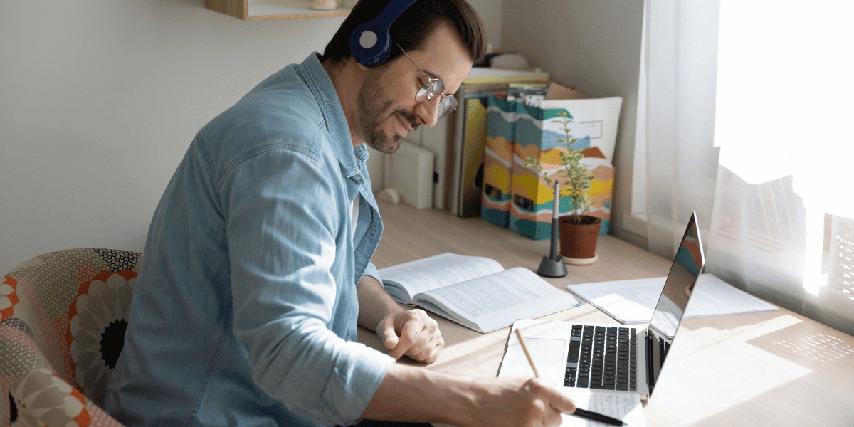 man in a blue shirt working on a macbook