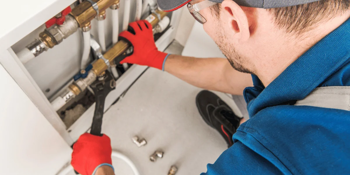 plumbing technician wearing safety gloves and glasses