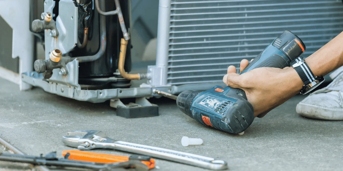 closeup of a power drill repairing a part of an hvac system.