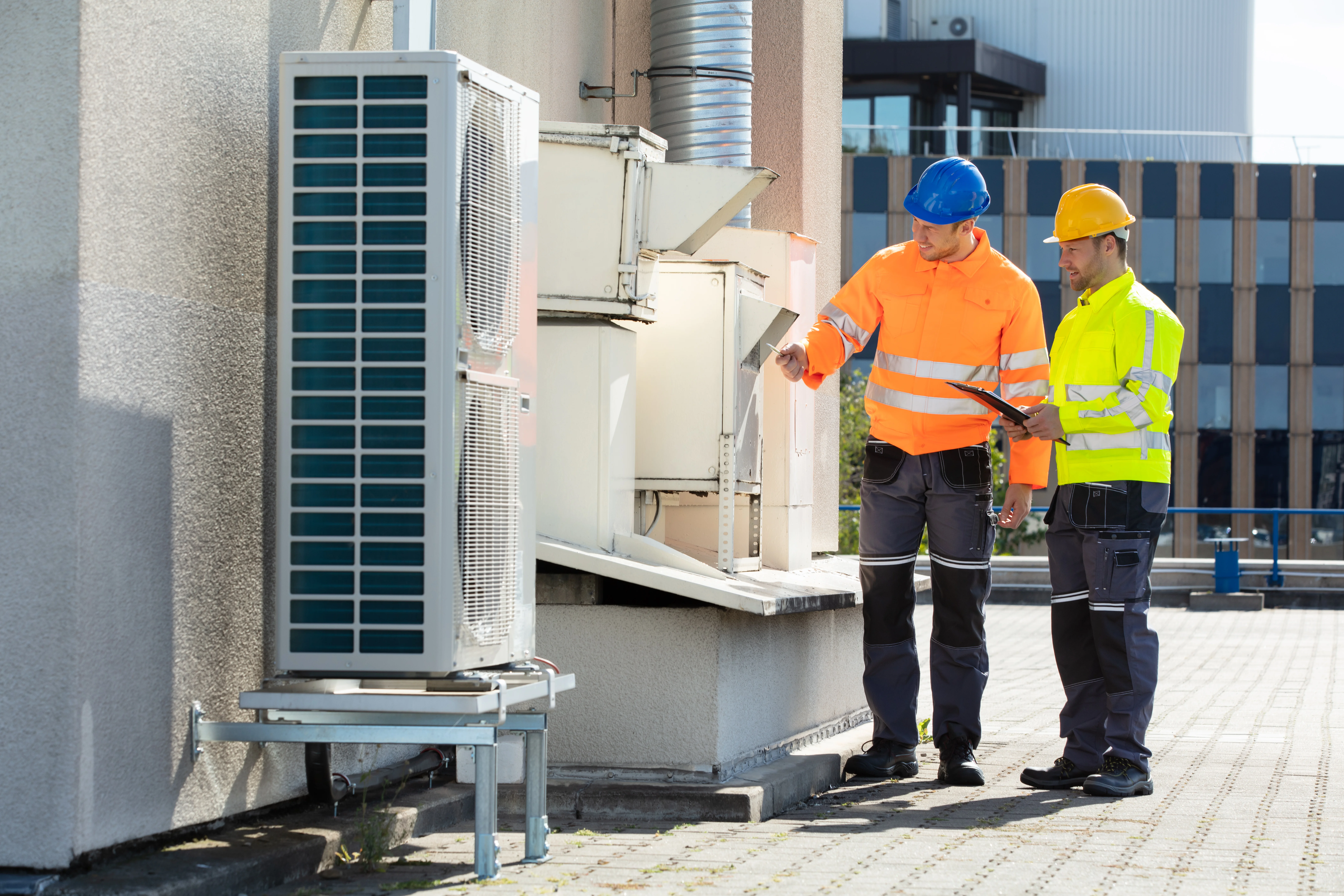 two working men checking on hvac and electrical
