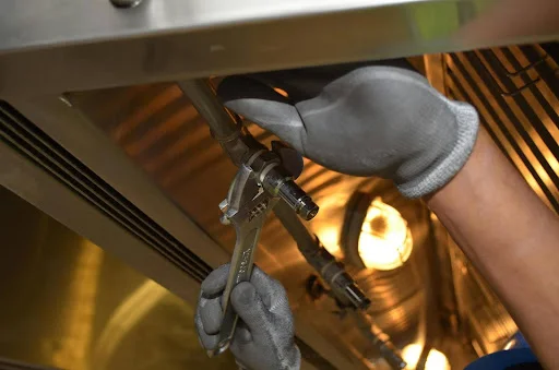 person using a wrench on a pipe