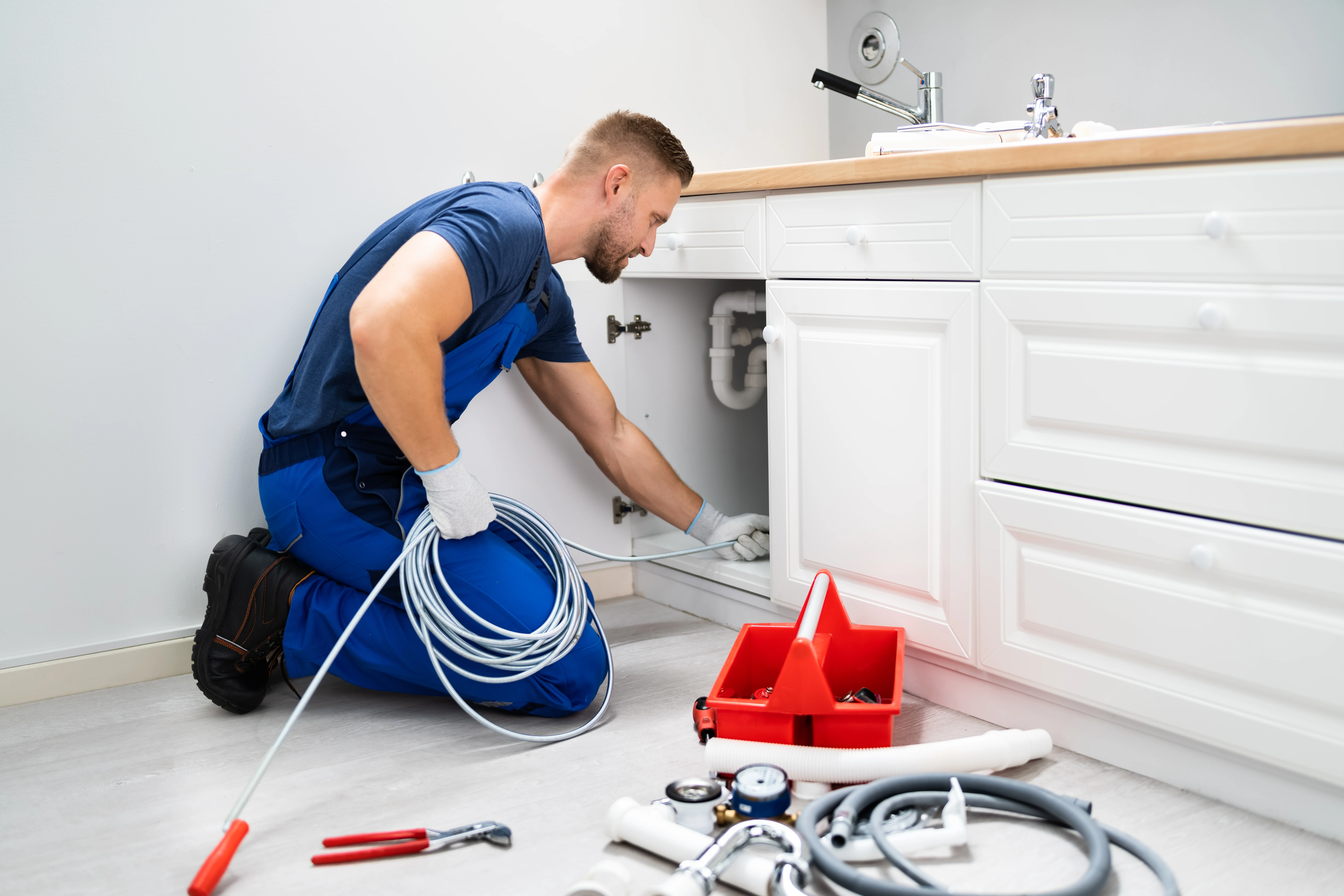Plumber working under a sink